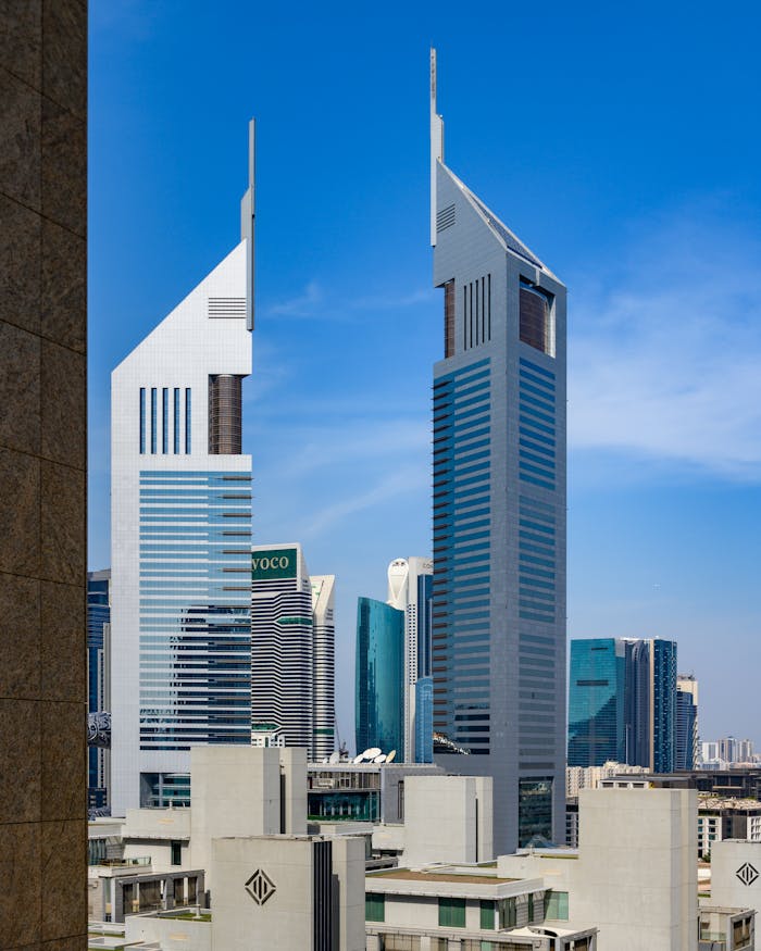 Striking view of the Emirates Towers in Dubai against a clear blue sky, highlighting modern architecture.